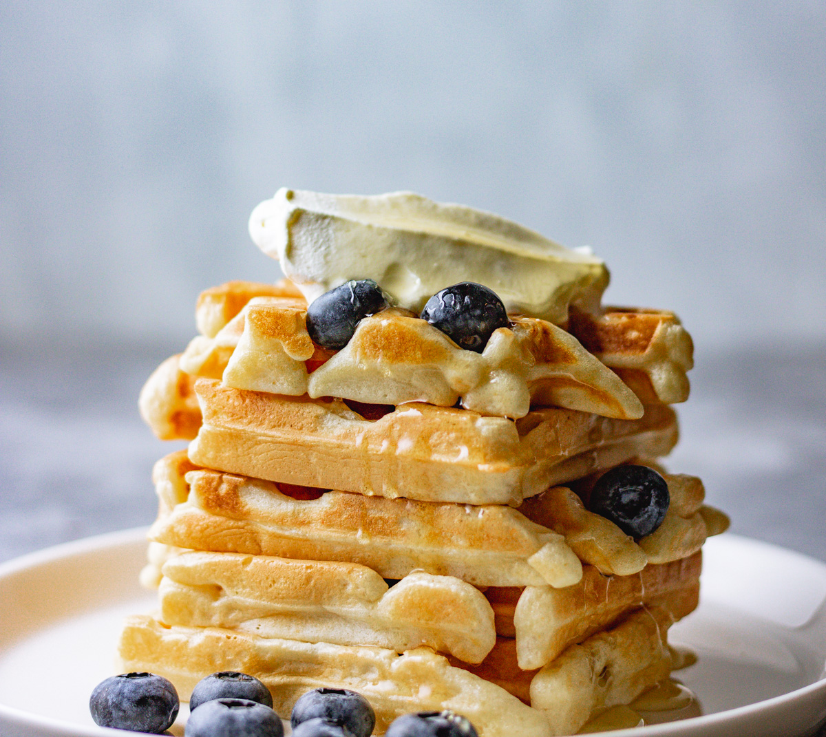waffles topped with fresh blueberries an cream.