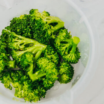 microwaved broccoli florets in a white bowl.