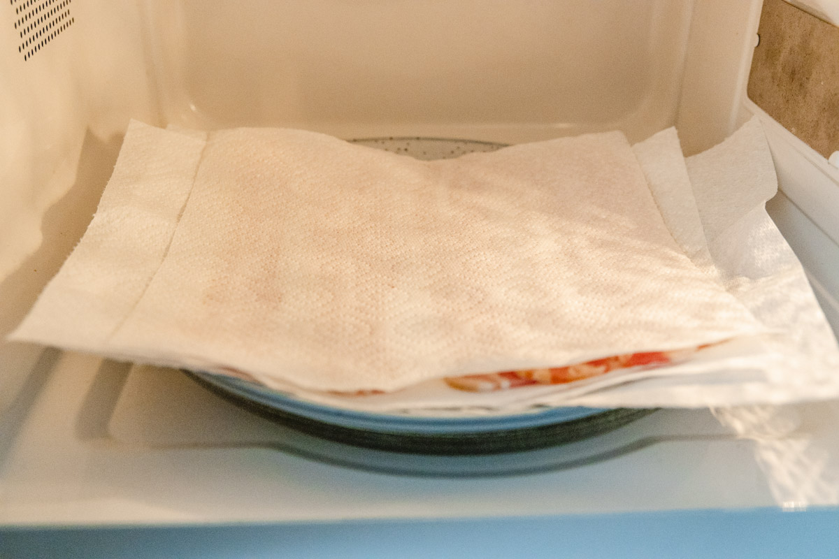 a plate of bacon in a plate covered with paper towel.
