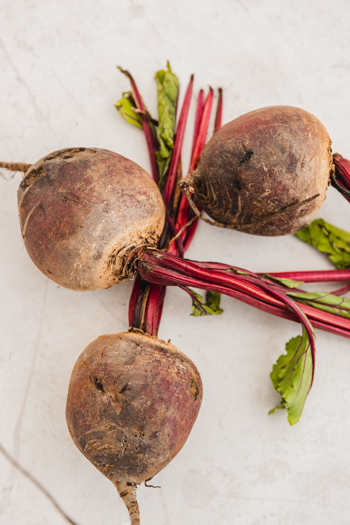 three large beets on a countertop.