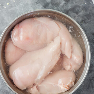 chicken breast brining in a bowl.